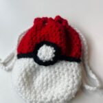 Texte alternatif : pochette Pokeball crochet faite main avec motif inspiré de la Pokeball