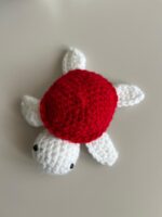 Tortue au crochet faite main vue de face Carapace rouge et bleue de la tortue au crochet Détails de la tortue au crochet faite main